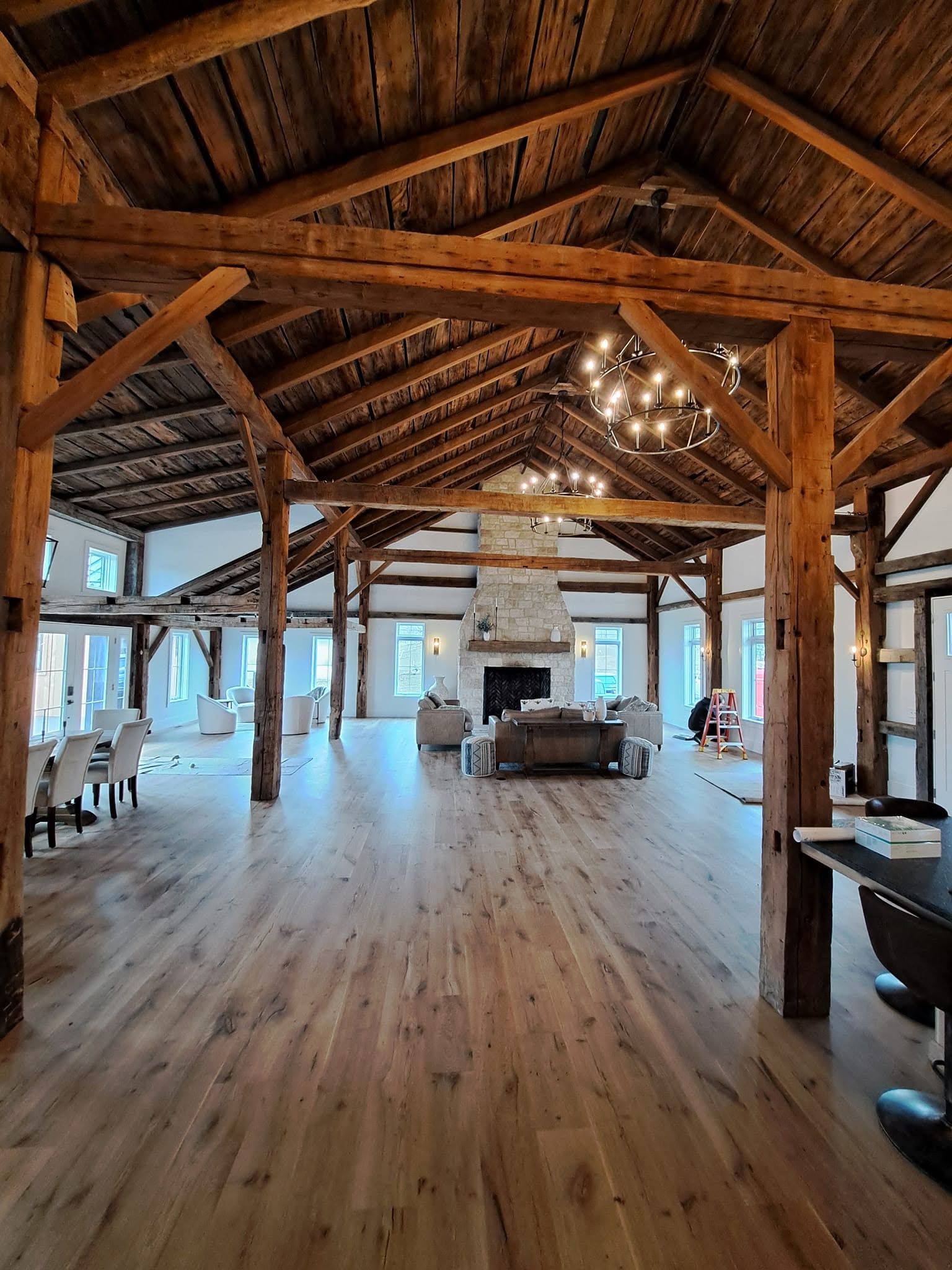 Wide-plank hardwood floor running through an open timber-frame great room