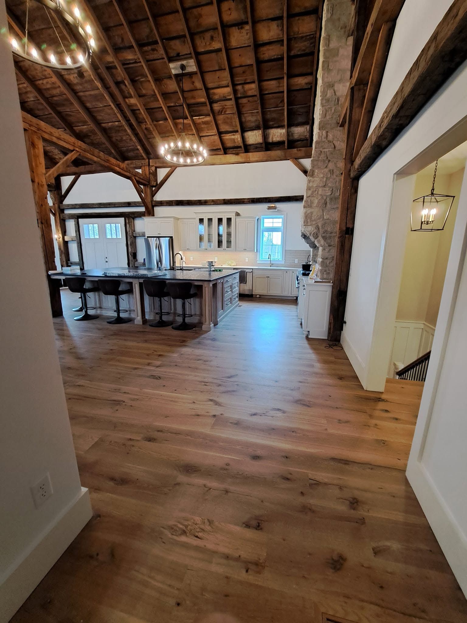 Loft view over hardwood floors in an open timber-frame dining area