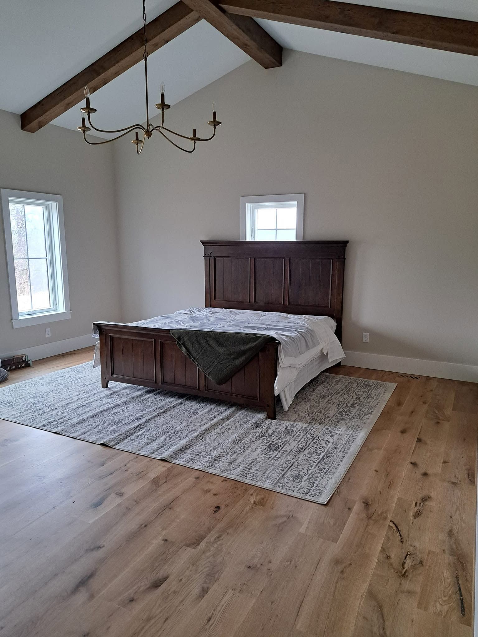 Hardwood floor in a bedroom with a wood-frame bed and area rug