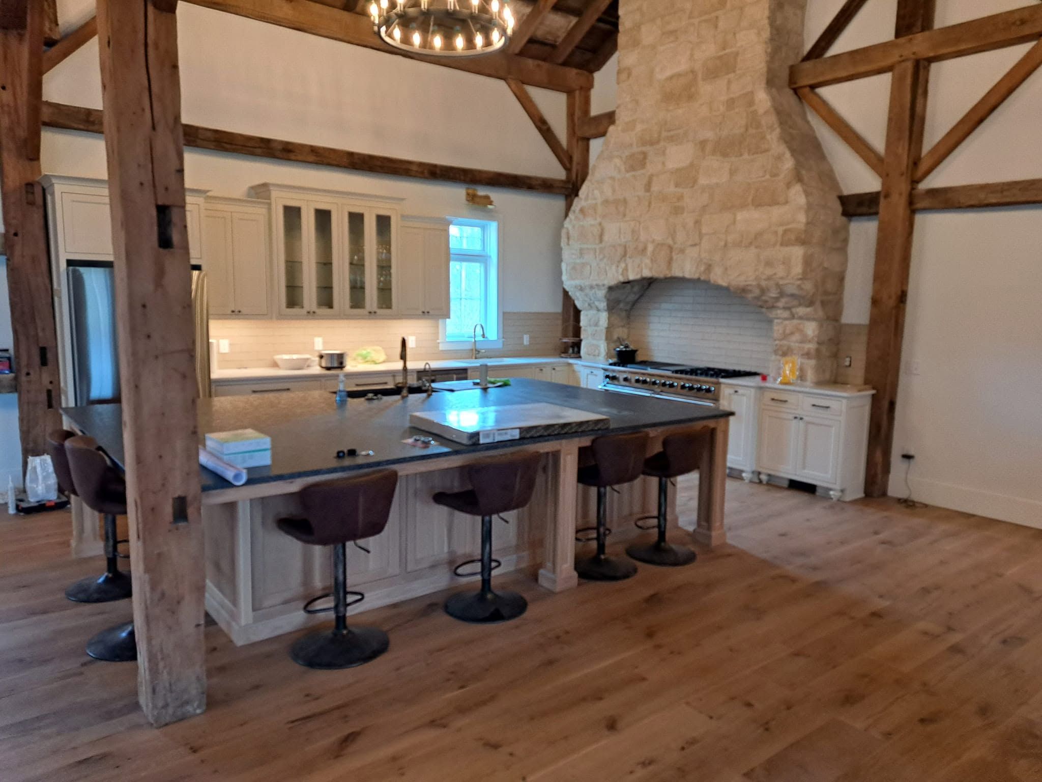 Hardwood flooring in a kitchen with a stone accent wall and breakfast seating